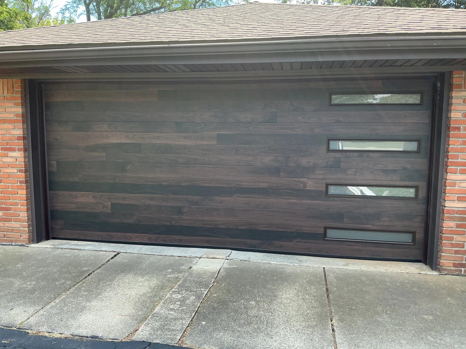 Wood look garage door with four narrow windows stacked along the right side in Canton.