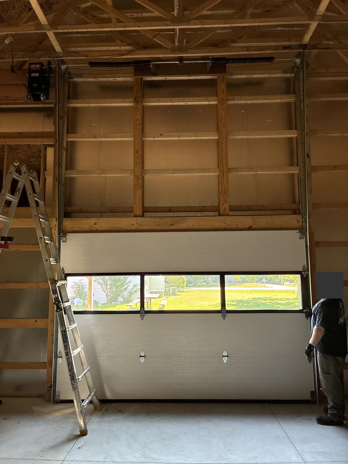 Barn door installation in progress with tracks extending above the opening.