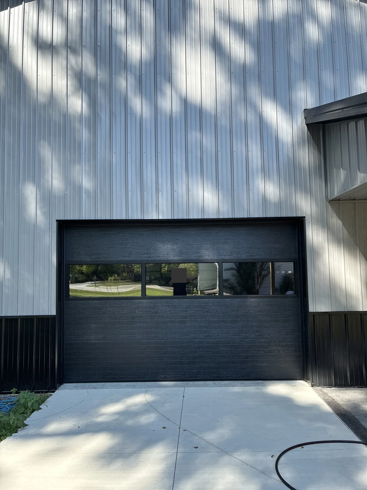Carbon Black overhead door with a horizontal glazed section at the shorter barn opening.